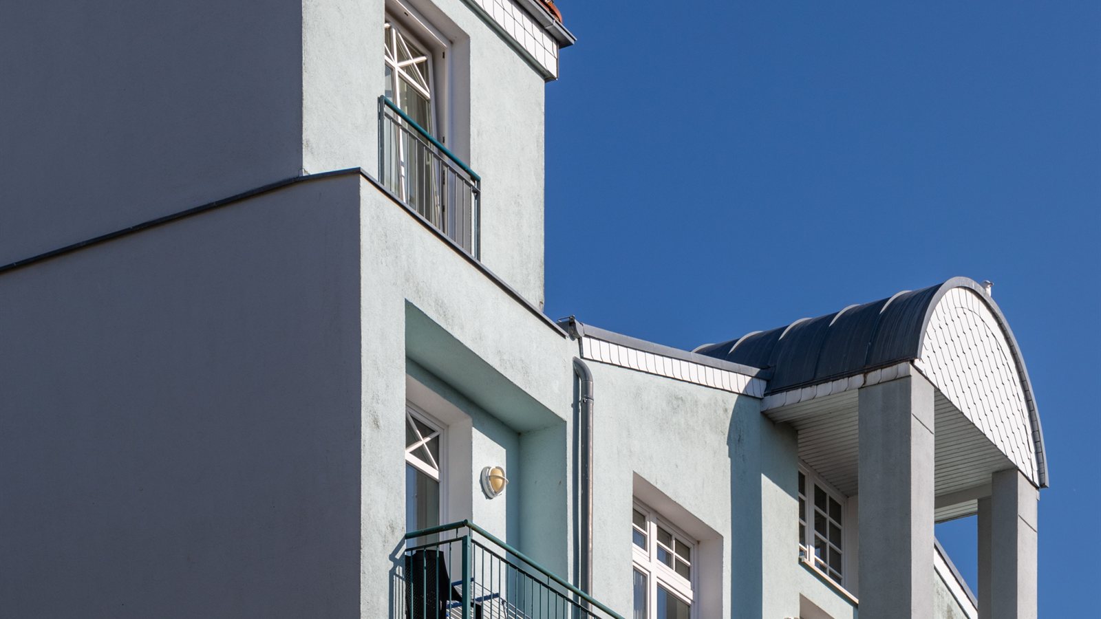 Apartment building with balconies against a deep blue sky